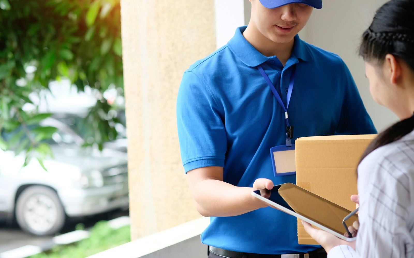 A courier handing a plain package to a patient at their front door